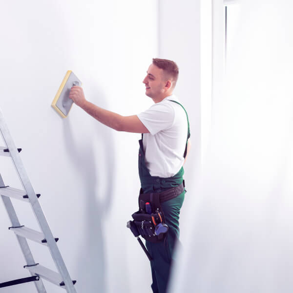 man-sanding-a-wall